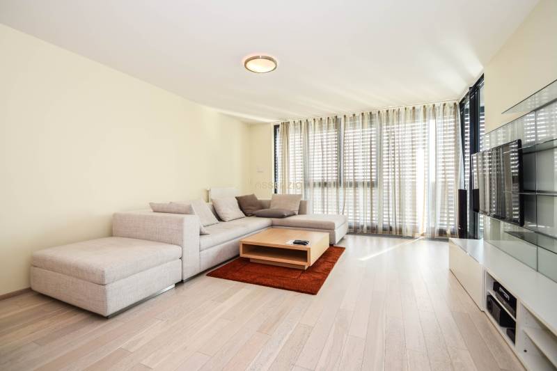 Living room in a 3-room apartment with a corner sofa, a coffee table, and a wooden decor floor.