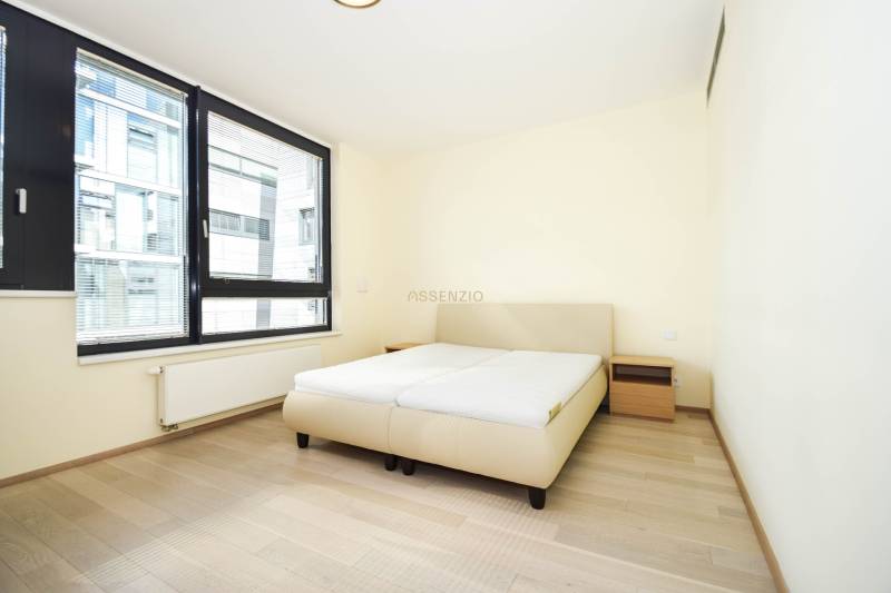 Bedroom with a bed, nightstands, and large windows, floor with wood decor.