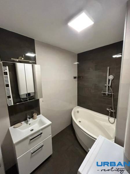 Bathroom with a shower, corner bathtub, sink, and tiles in a 3-room apartment.