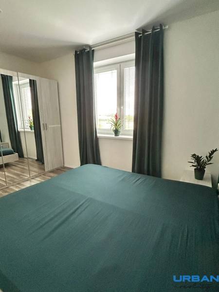 Bedroom in a 3-room apartment with a mirrored wardrobe, curtains, and a wooden decor floor.