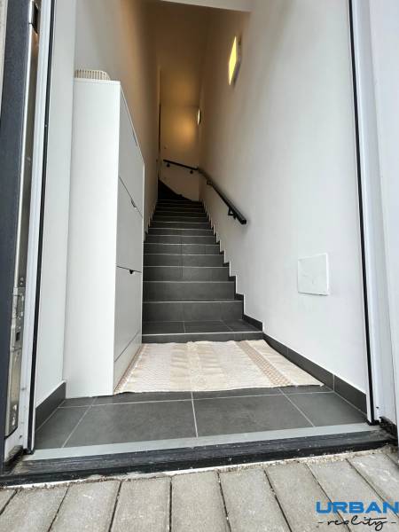 Entrance area with dark tiles and stairs in a 3-room apartment.