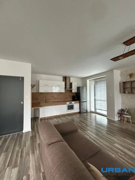 Living room with a kitchen unit and a wooden decor floor in a 3-room apartment.