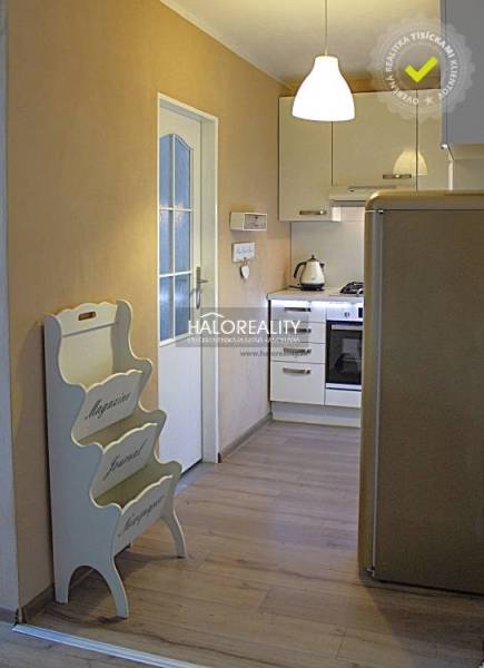 A kitchen in a 2-room apartment with a wooden decor floor and white appliances.
