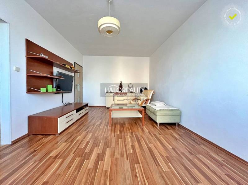 Living room in a three-room apartment with a wooden decor floor and furniture.