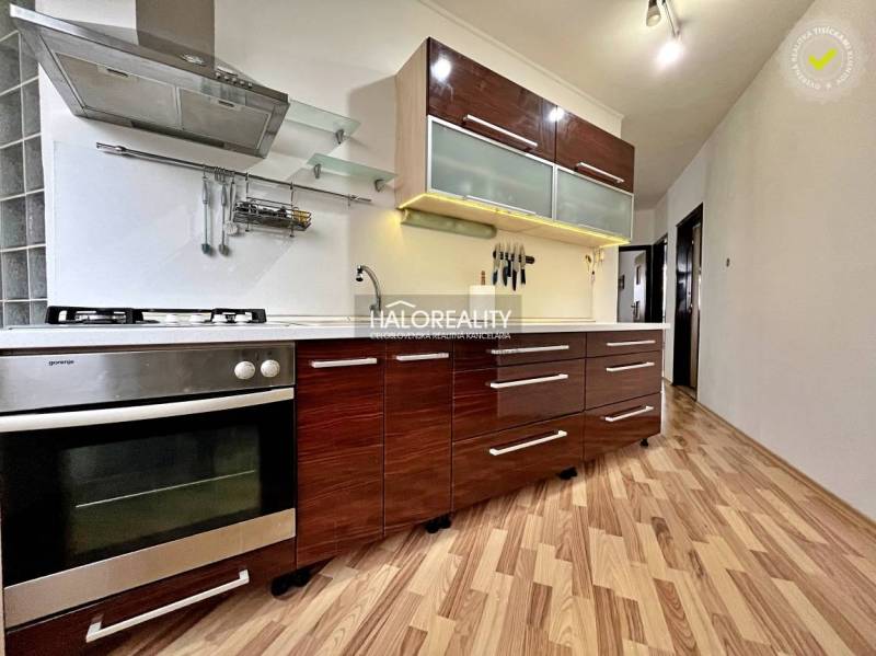 Kitchen in a 3-room apartment with wood-patterned flooring, spacious cabinets, modern appliances.