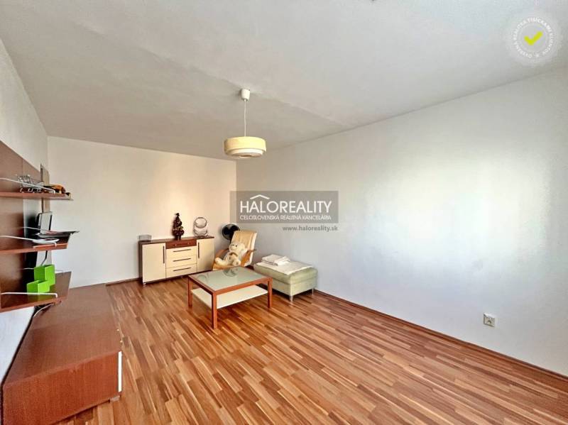 Living room in a 3-room apartment with a wooden decor floor, minimalism, light walls, furniture.
