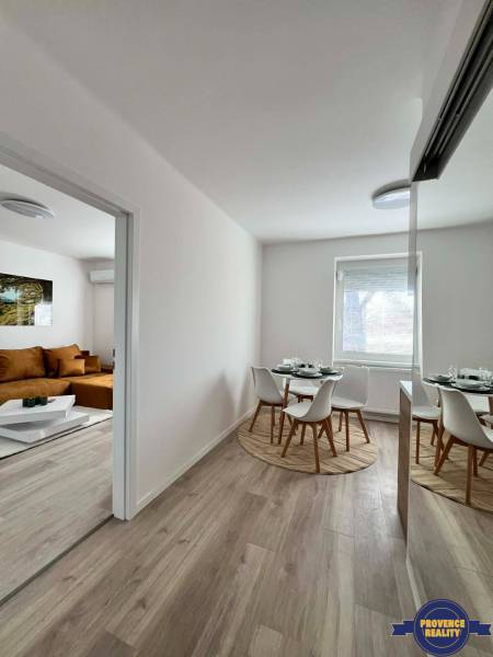 Dining area with a round table in a 2-room apartment with a wooden decor floor.