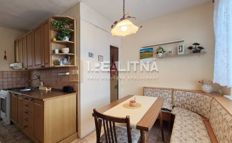 A kitchen in a 2-room apartment with a corner bench, wooden decor, and rustic lighting.