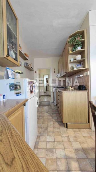 A kitchen in a 2-room apartment with a wooden decor and white walls.