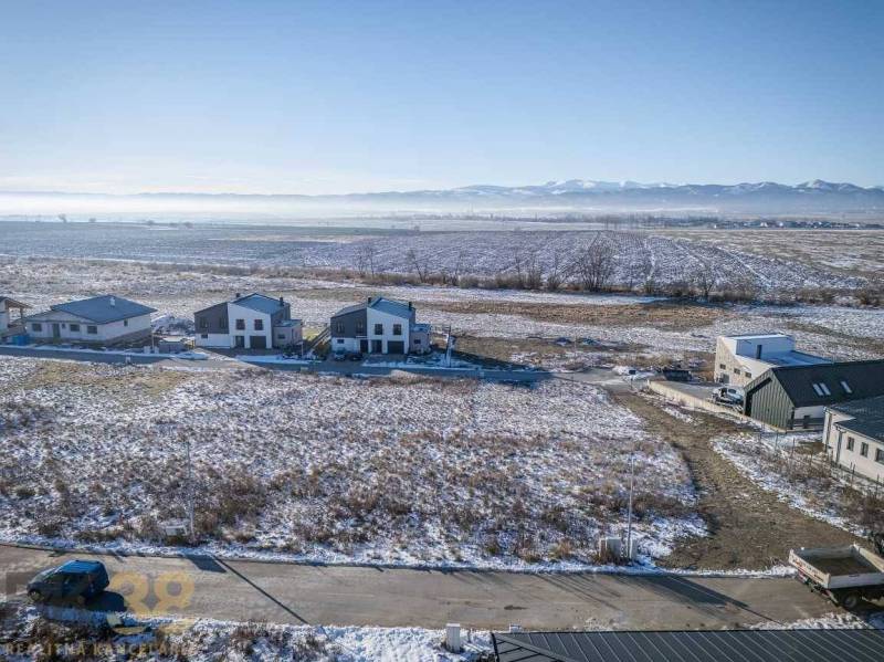 Mlynica: Lands - housing with snow-covered fields and houses, surrounded by forests and roads.