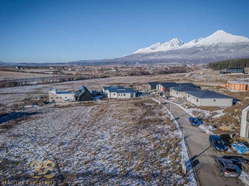 Plots for residential housing in Mlynica with unfinished houses and a snowy landscape.