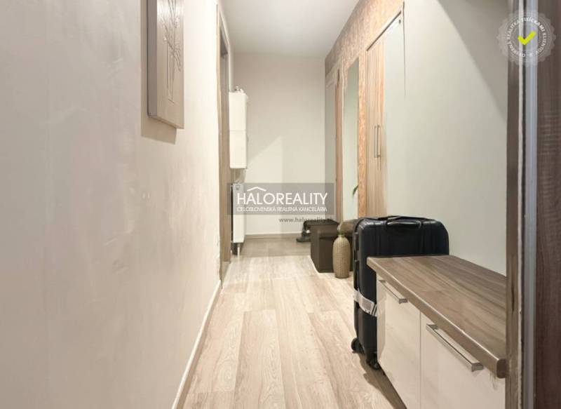 A hallway with a wood-patterned floor and storage space in a 2-room apartment.