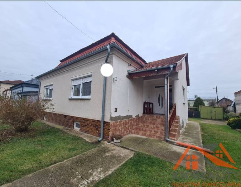 A family house in Hurbanovo with a red roof and a front garden with a lawn.