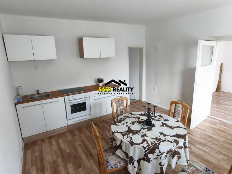 Kitchen and dining area with wood-patterned flooring in a family house.