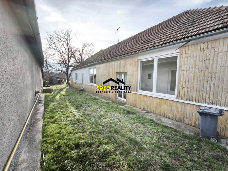 A family house in Lúčnica nad Žitavou with wooden cladding and a garden.