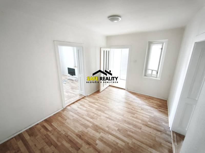 A room in a family house with a wooden decor floor and simple furnishings.