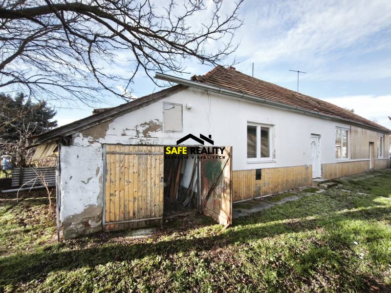 A family house in Lúčnica nad Žitavou with a bright facade and a garden on a sunny day.