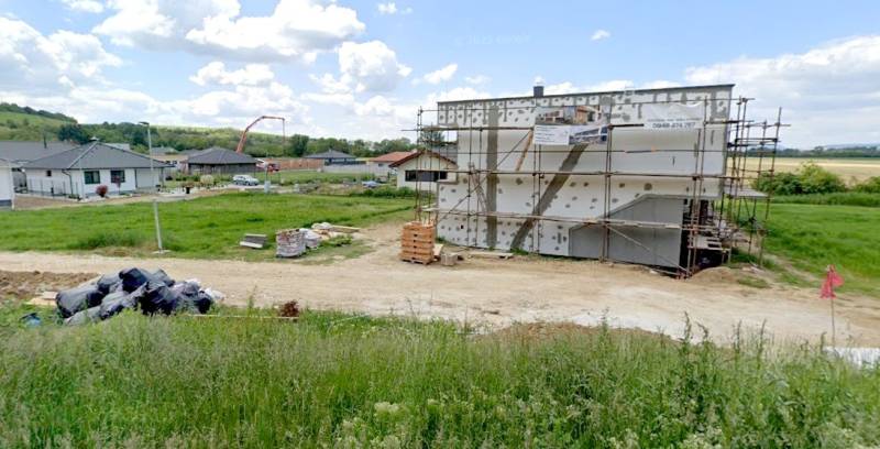 A residential building plot in Modrovka with an unfinished building and surroundings in the background.