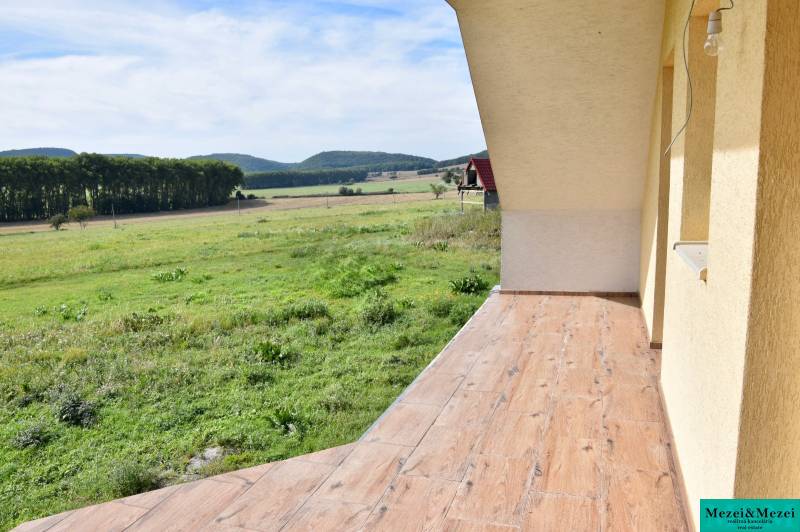A family house in Buková with a terrace and a wooden decor floor, overlooking the fields.