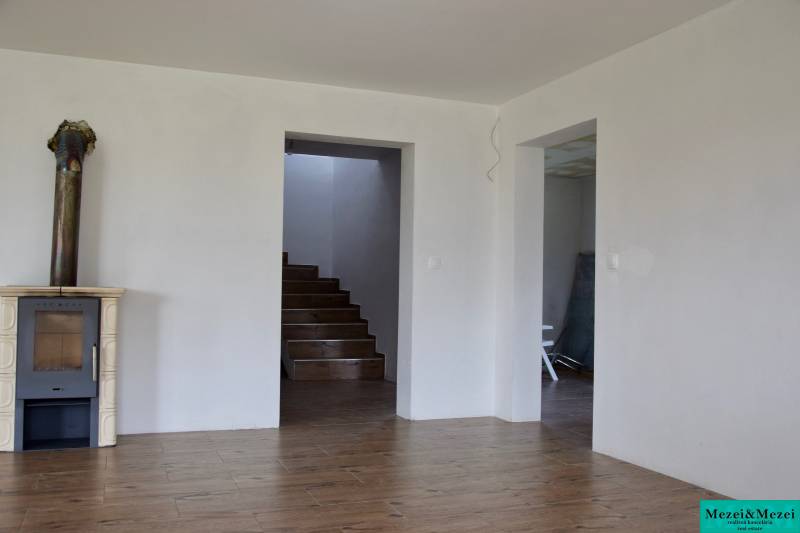 Interior of a family house with a fireplace, staircase, and floor with wood decor.