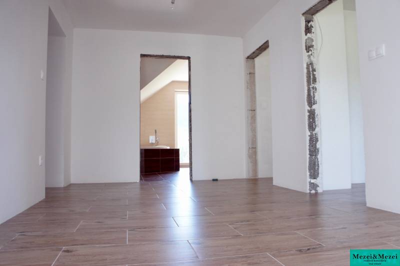 The interior of a family house with a wooden decor floor and uncovered construction openings.