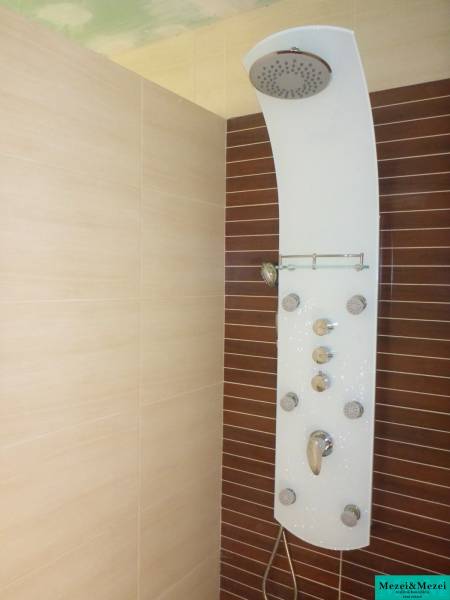 Shower panel on the wall with tiles in a family house.