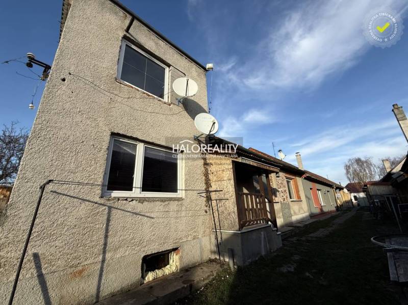 A family house in Chynorany with satellites and a garden, next to other houses.