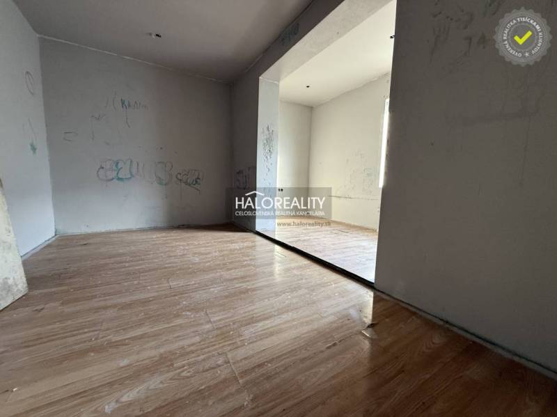 A room in a family house with a wooden decor floor and simple walls.