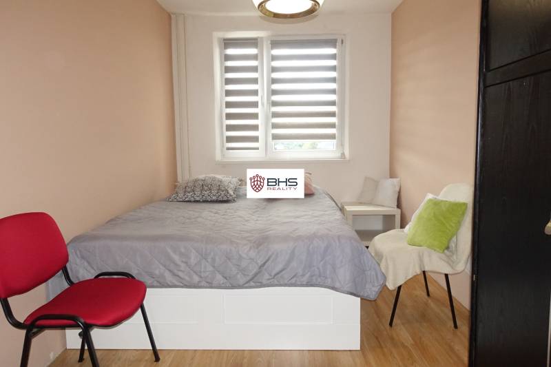 Bedroom in a 3-room apartment with a bed, chairs, and a wooden decor floor.