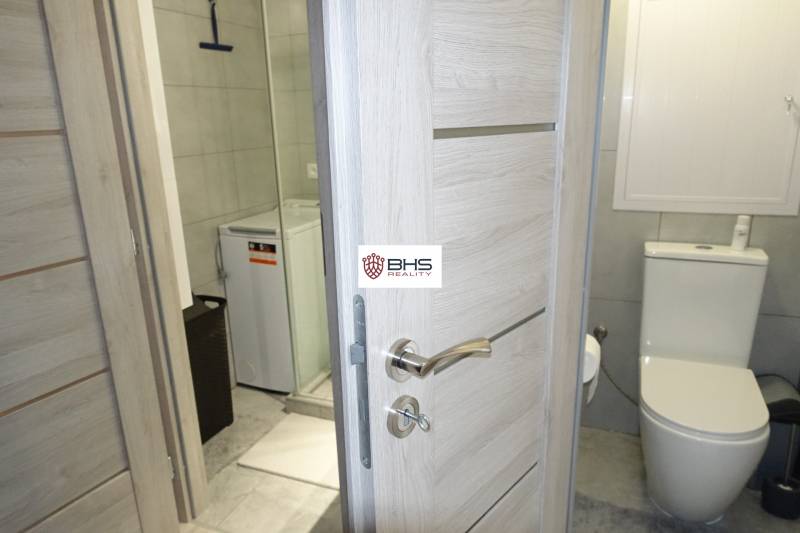 Bathroom in a 3-room apartment with a shower, washing machine, and toilet.