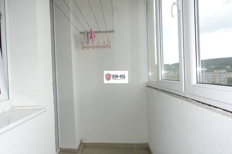 A glazed balcony in a 3-room apartment with a view of the city district.