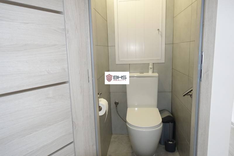 A bathroom in a 3-room apartment with tiled floors and gray walls.