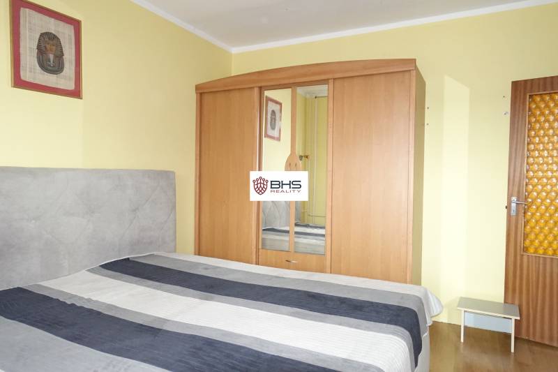 Bedroom with a bed, wardrobe, and decoration in a 3-room apartment.