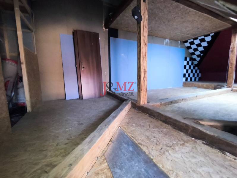 Attic space in a family house with wooden elements, checkerboard wall.