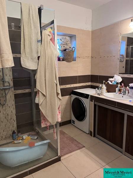 A bathroom in a 4-room apartment with a washing machine and a shower.