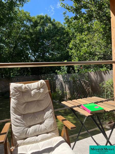 Relax on the terrace of a house in Bratislava - Vrakuňa with a lounger and a table under the blue sky.