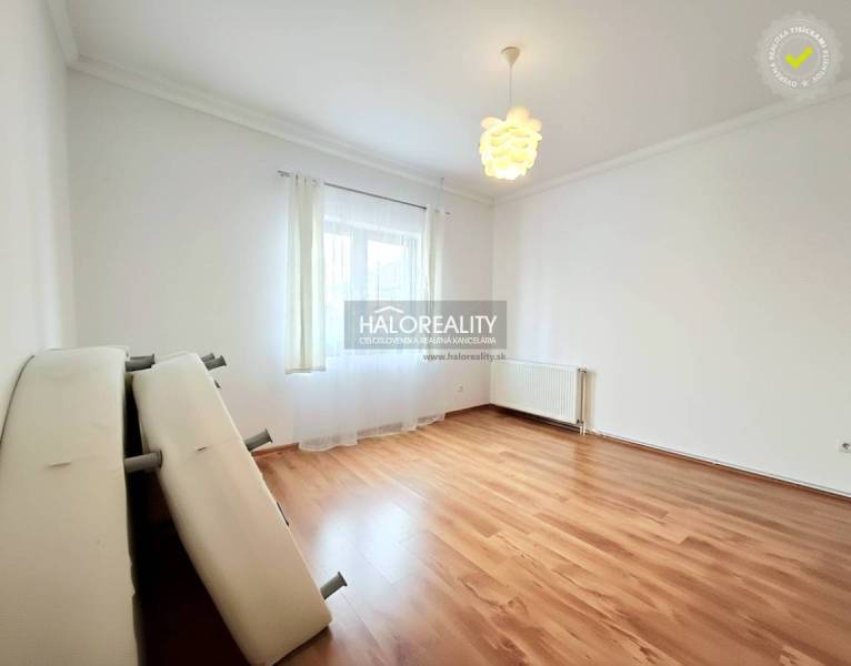 A spacious room with a wooden decor floor and light furnishings in a family house.