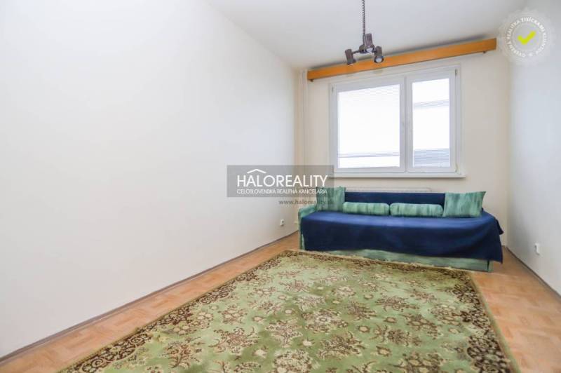 A simple room with a carpet and a sofa in a 3-room apartment, floor with wood decor.