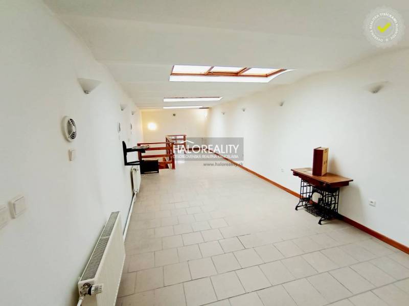 A bright hallway in a family house with white walls and skylights.