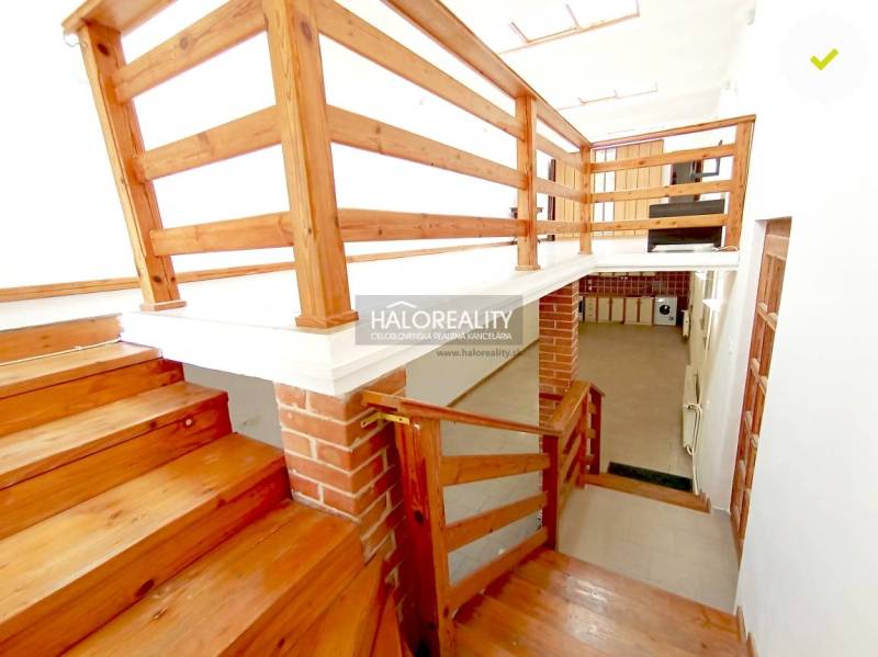 Wooden stairs and railings in a family house with a brick detail on the wall.