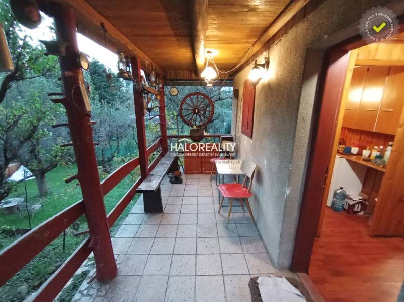 An outdoor terrace with wooden railing and a garden by the cottage, offering tranquility.