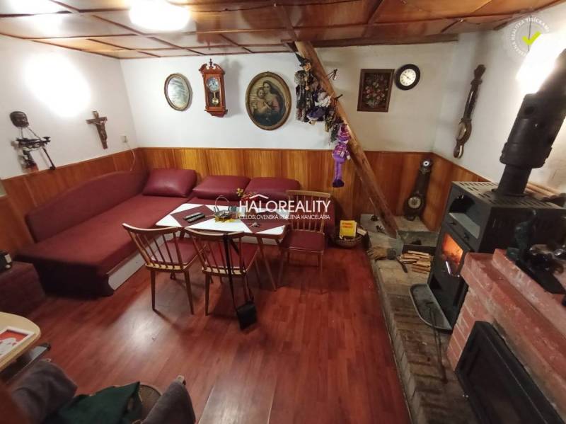 Rustic cottage, wooden ceiling, fireplace, comfortable sofa, traditional interior, cozy atmosphere.