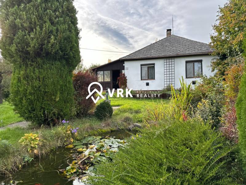 A family house in Kalša with a beautiful garden and a small pond surrounded by greenery.