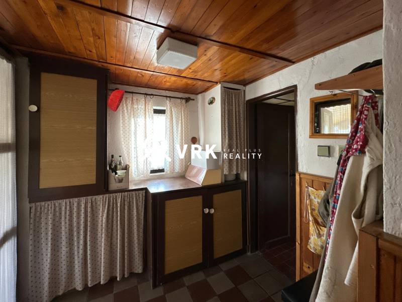 Interior of a family house with a wooden ceiling and curtains, a cozy nook with decorative elements.