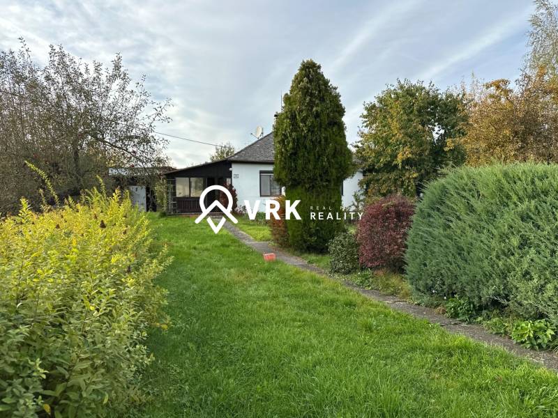 A family house in Kalša surrounded by a garden with diverse vegetation.