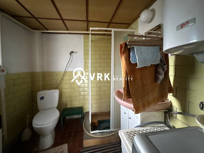Bathroom in a family house with a toilet, shower, and sink.