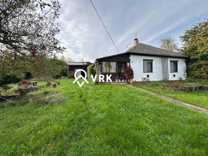 A family house in Kalša surrounded by a garden and fruit trees, with a manicured lawn.