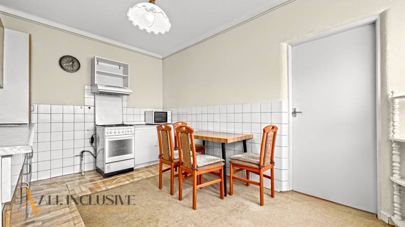 Kitchen in a family house with a dining table, chairs, and a stove.