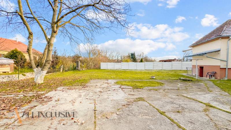 A courtyard at a family house on Nemečkovská Street in Prašice with a paved area and trees.