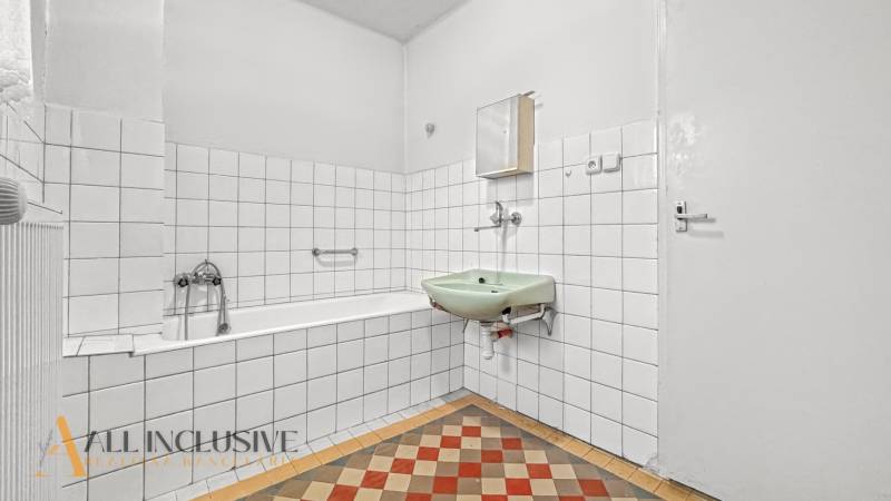 A bathroom in a family house with a classic sink and bathtub with white tiles.